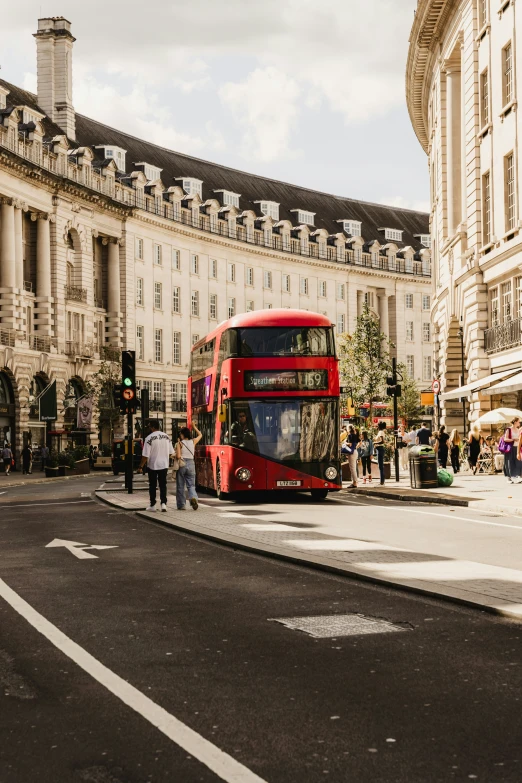 two buses driving down a street near tall buildings