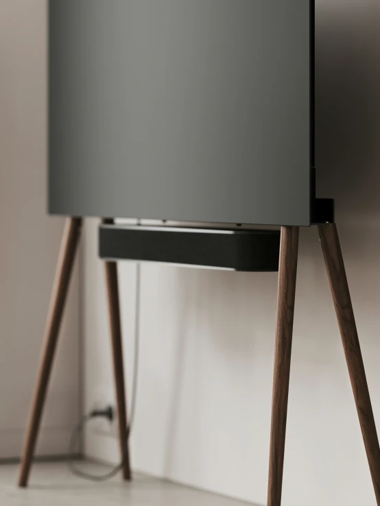 a modern stereo with black speakers and wood legs