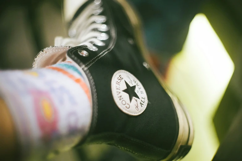 a man putting on some black shoes with his hands