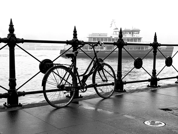 a bicycle parked against a railing overlooking the water