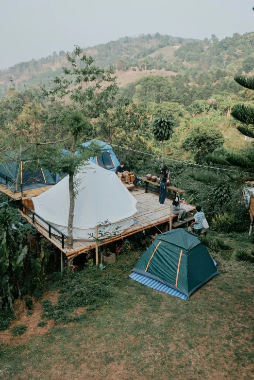 people standing in front of tents set up on top of a hill