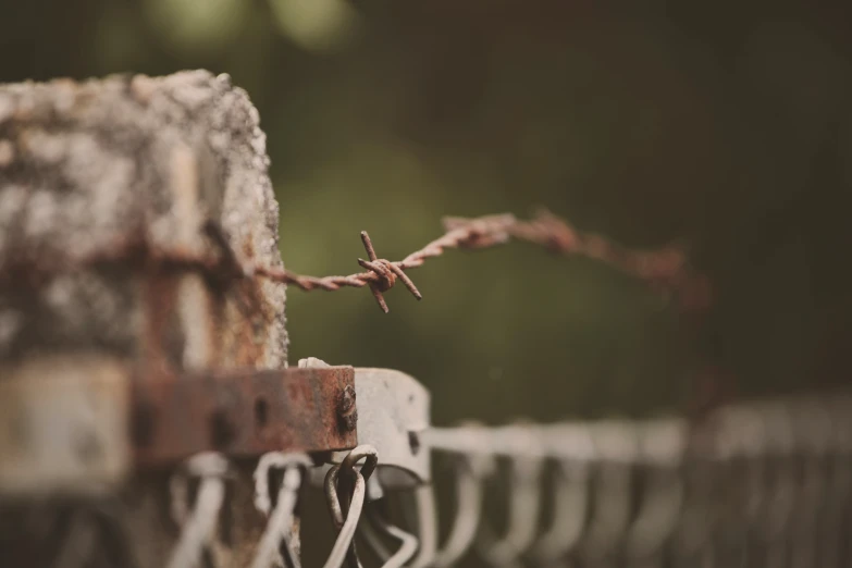 a barbed wire fence behind an old metal rail