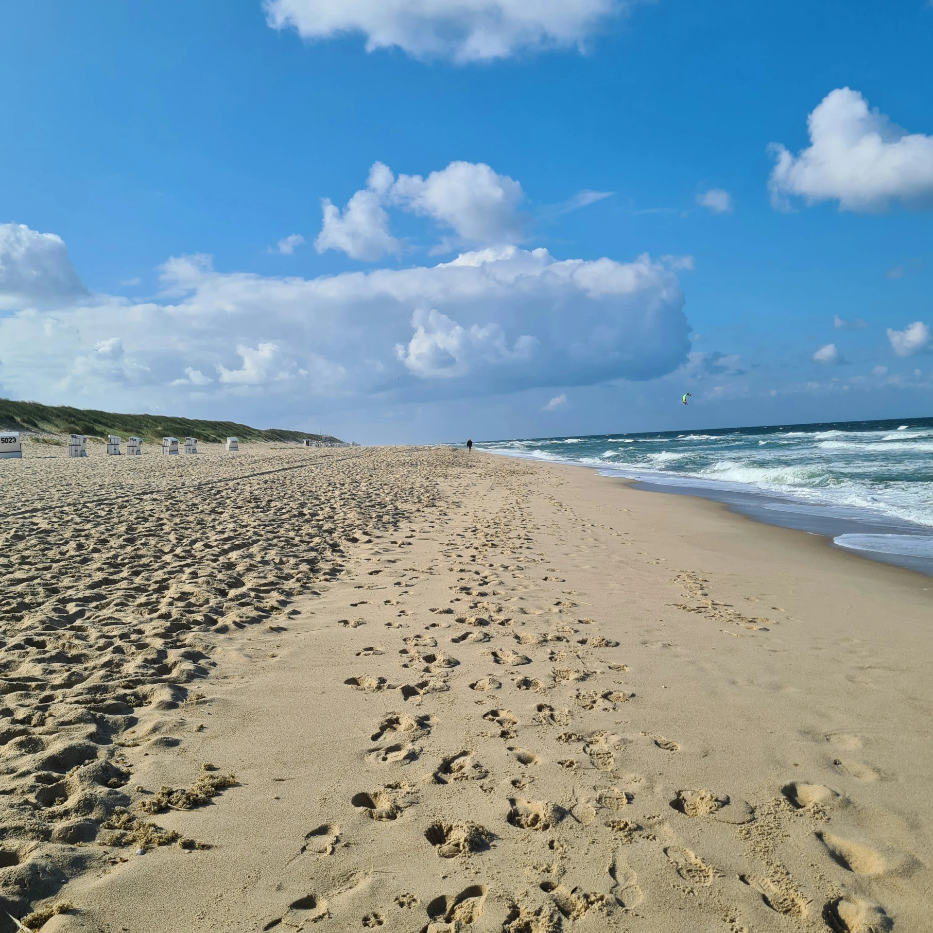 a sandy beach with waves coming in