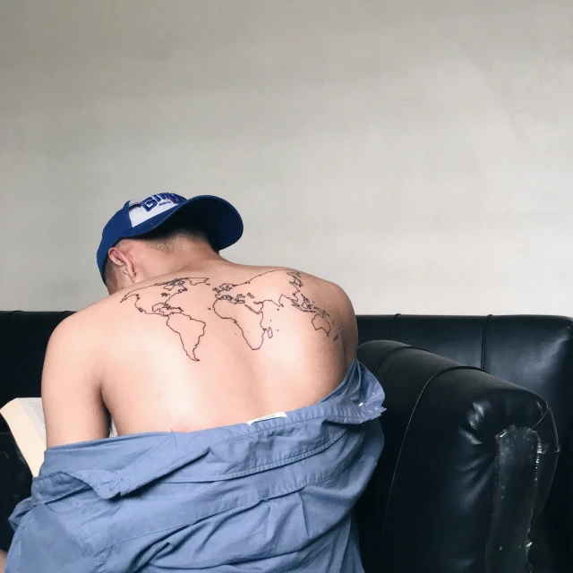 a man has a tattoo of the world in his chest