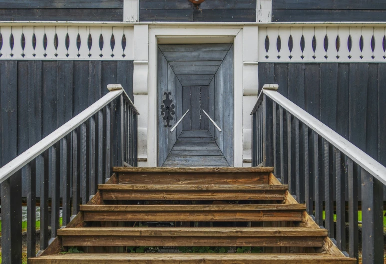 a door on a wall and staircase going up