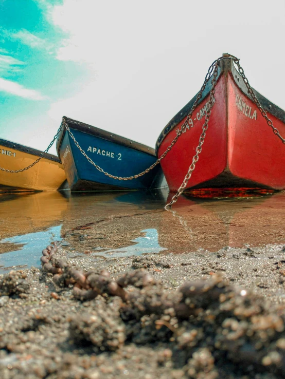 three boats with chains tied to them are parked