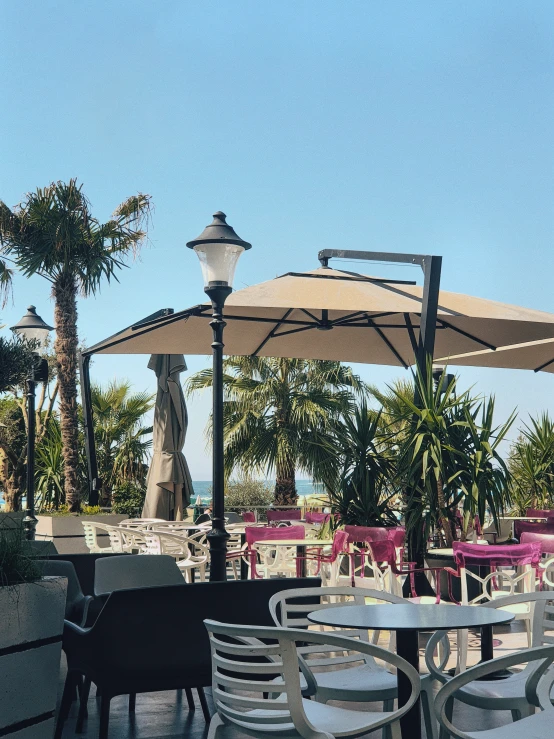 a couple of tables sitting under umbrellas on top of a pier