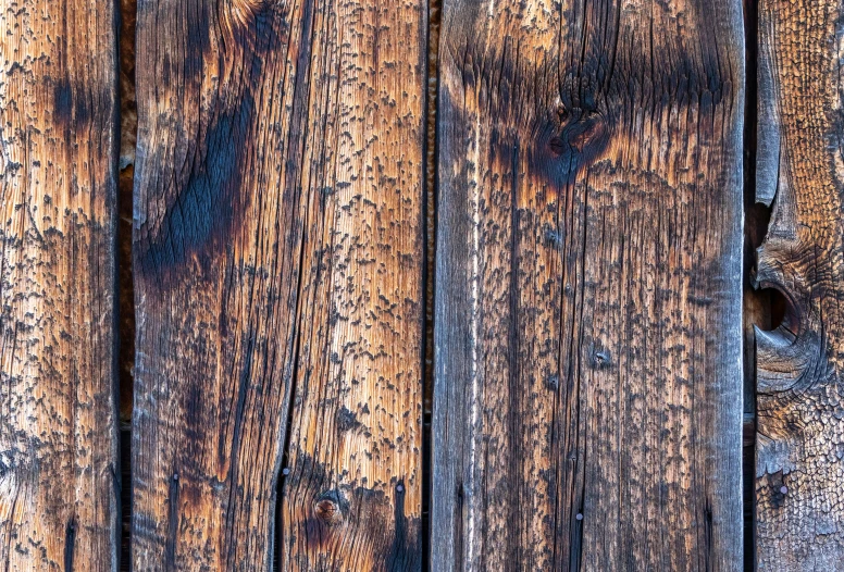 a rustic wooden surface with small holes and some rust