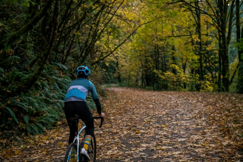 the man is riding a bike down a path in the woods