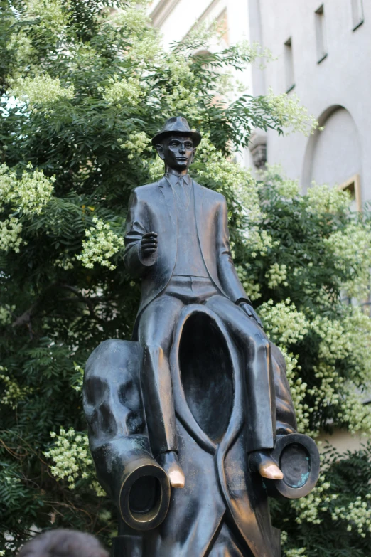 the statue is holding a hat and a cane