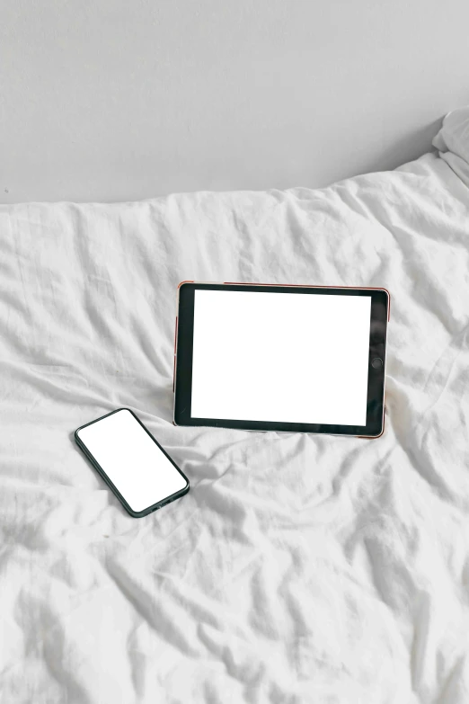 two cell phones are laying next to each other on a bed