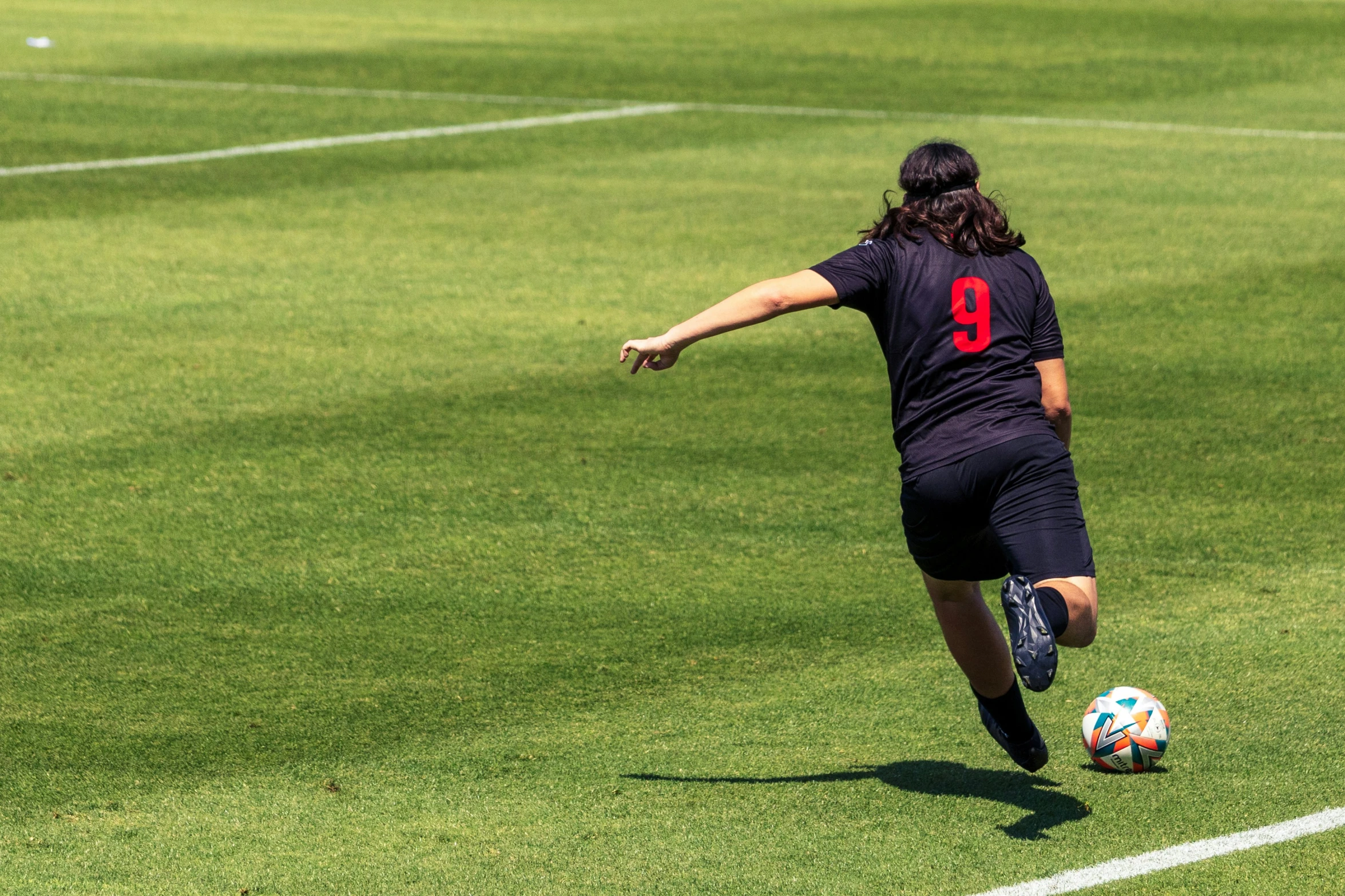 a woman that is kicking a soccer ball