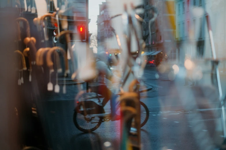 the reflection of people riding bicycles and cars in a window