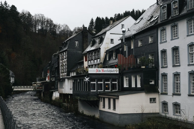 a river running by houses with buildings near by