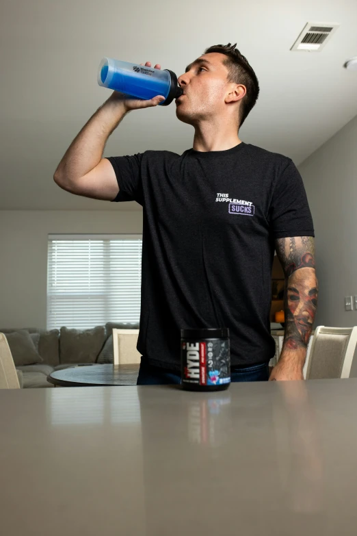 a man drinking from a blue water bottle