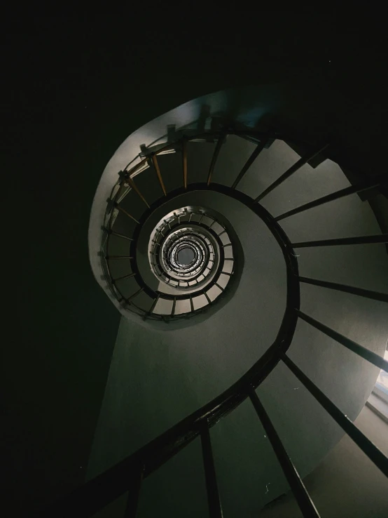 looking up at a circular stair railing on an empty building