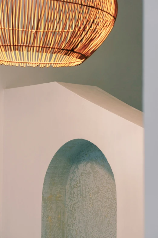 a white wall and a hanging lamp made of raftons
