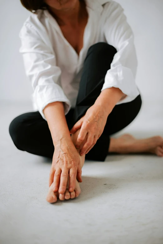 woman in white shirt kneeling on floor with both hands extended