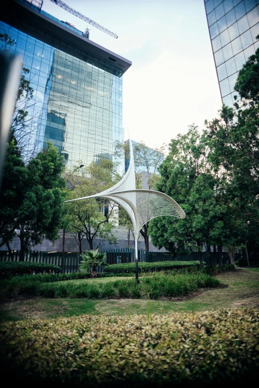 the top of a sculpture sits in front of a tall building