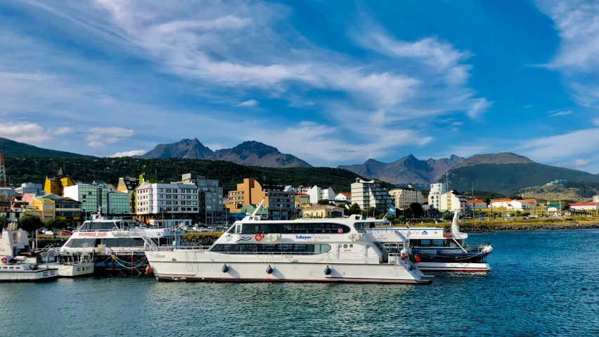 several boats are docked in a bay in front of buildings