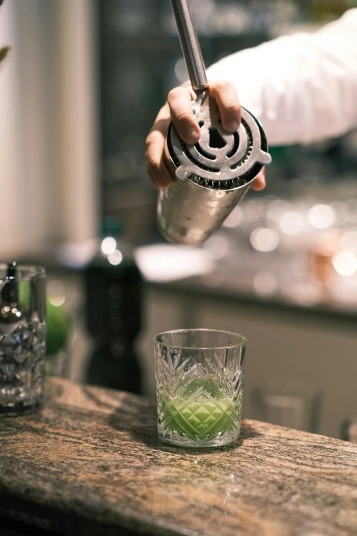 a person is holding a small object over a bar