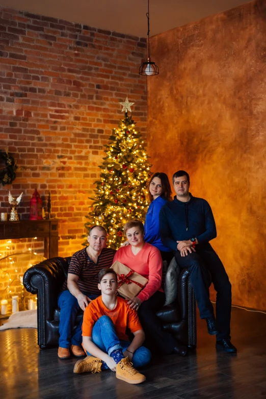 a family posed in front of a decorated christmas tree