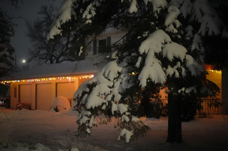 a house with some snow and the front of the house lit up