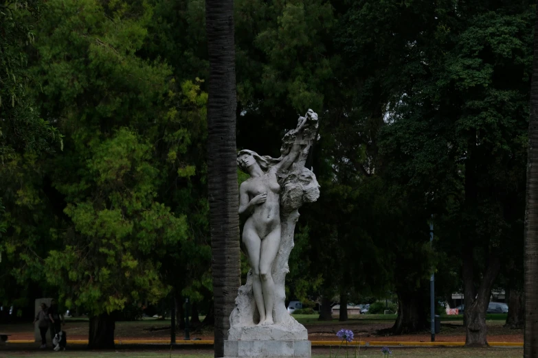 statue in the middle of a park in front of trees