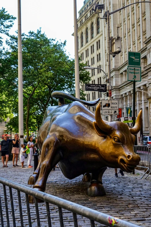 a bull statue standing outside on a brick road