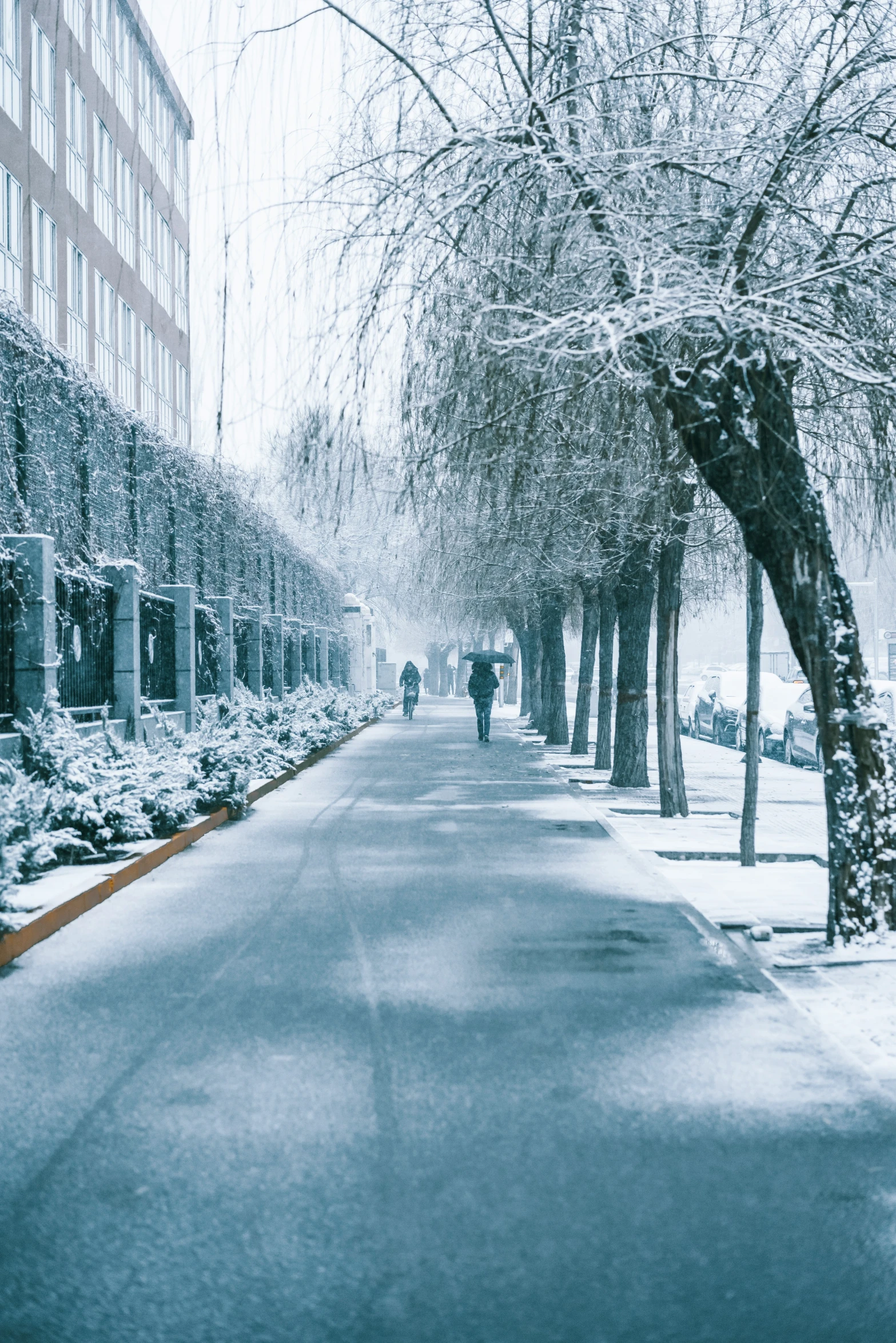 a city street that has a person walking on it and is covered in snow