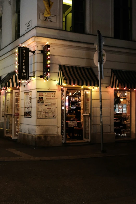 storefronts lit up at night with small awnings