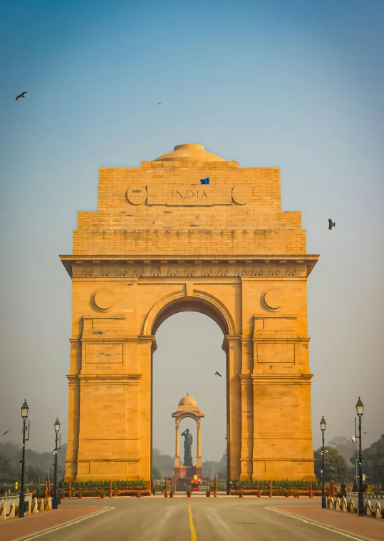 a very big stone archway by the side of the road