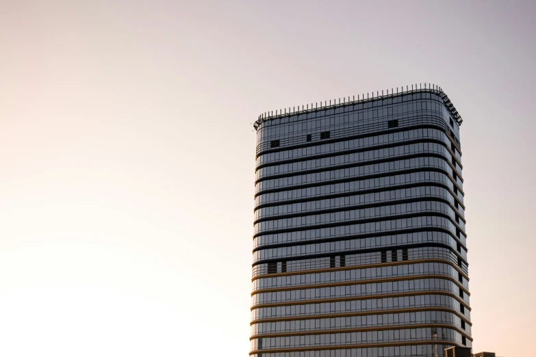 a building with a very tall roof sits near a large boat