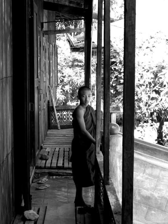 a woman wearing an robe standing on a porch