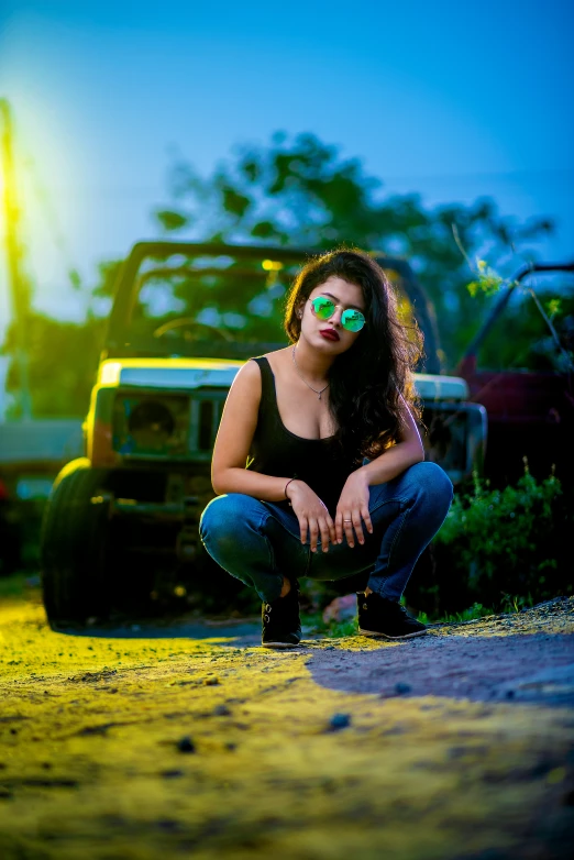 a woman in sunglasses posing in front of a truck