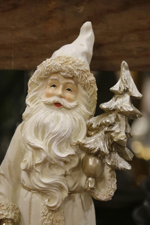 a statue of santa claus holding three silver christmas trees