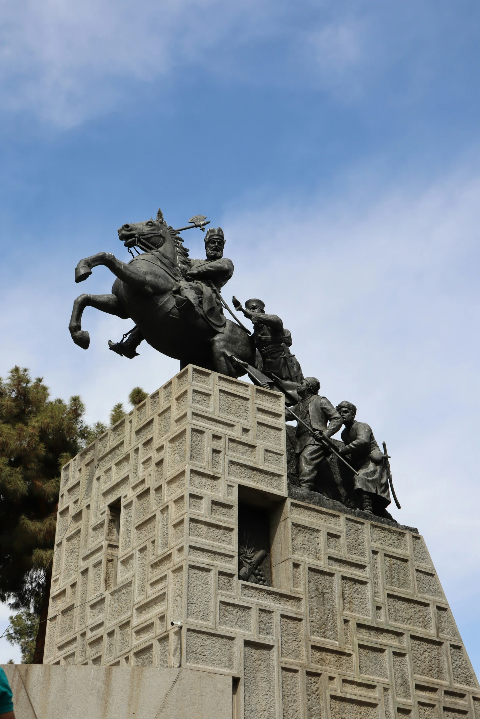 the statue is of a man riding on a horse and other people looking up at the sky