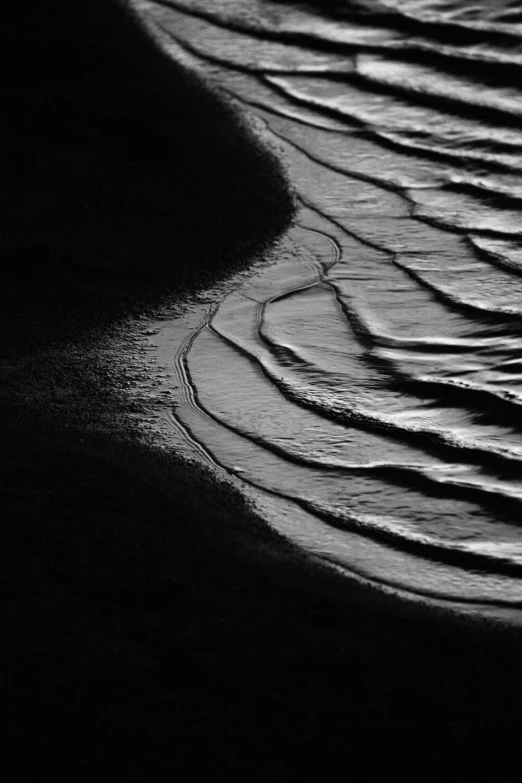 black and white image of sand with wavy edges