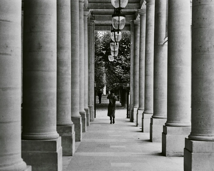 a man walking down a street next to tall buildings