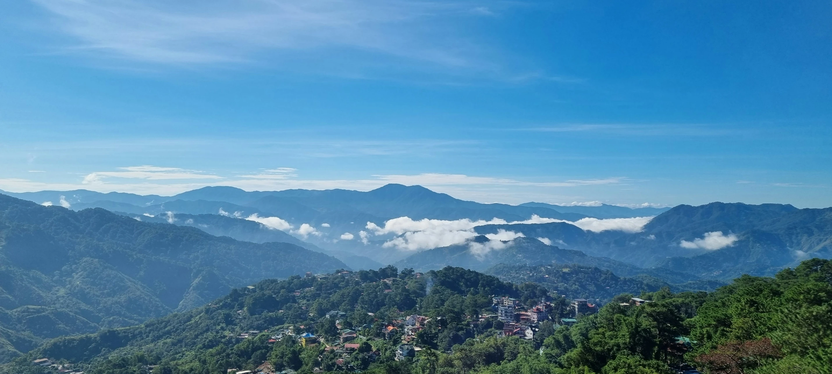 a scenic view over the valley and mountains with mist in the air