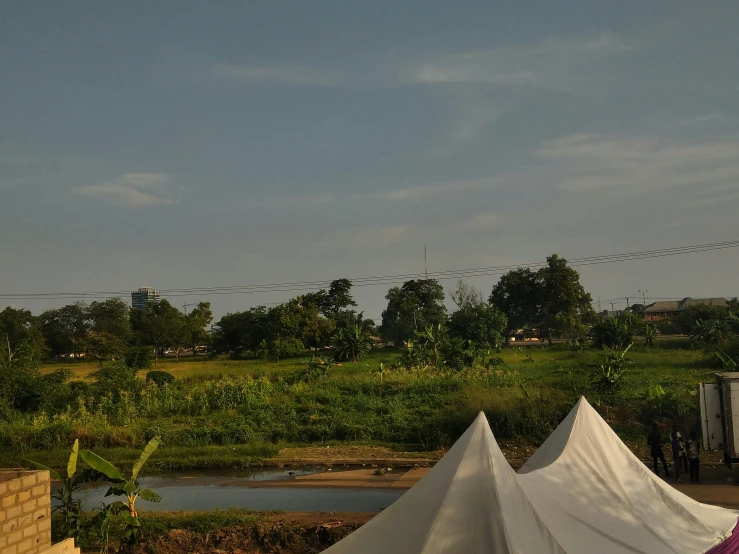 a row of tents are outside by some grass