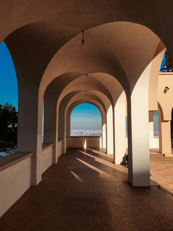 the light is shining through the arch shaped walkway