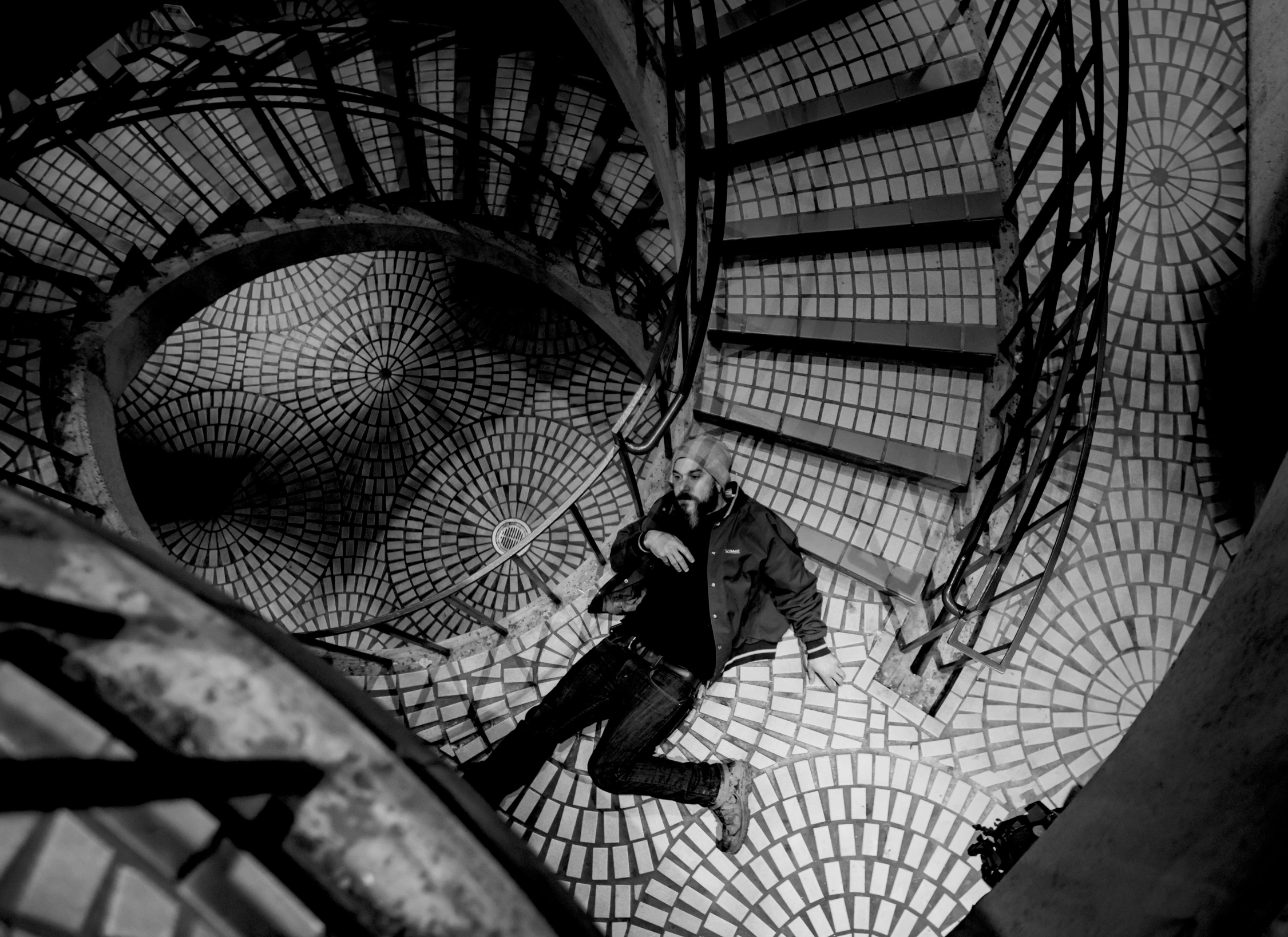 a man standing in front of a spiral stair