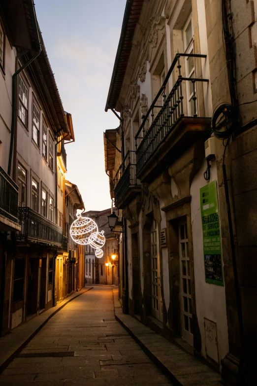 a street with buildings and lights during the dusk