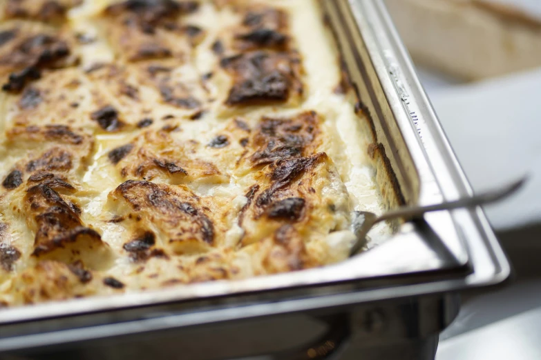 a baked dish is being prepared and placed on a table