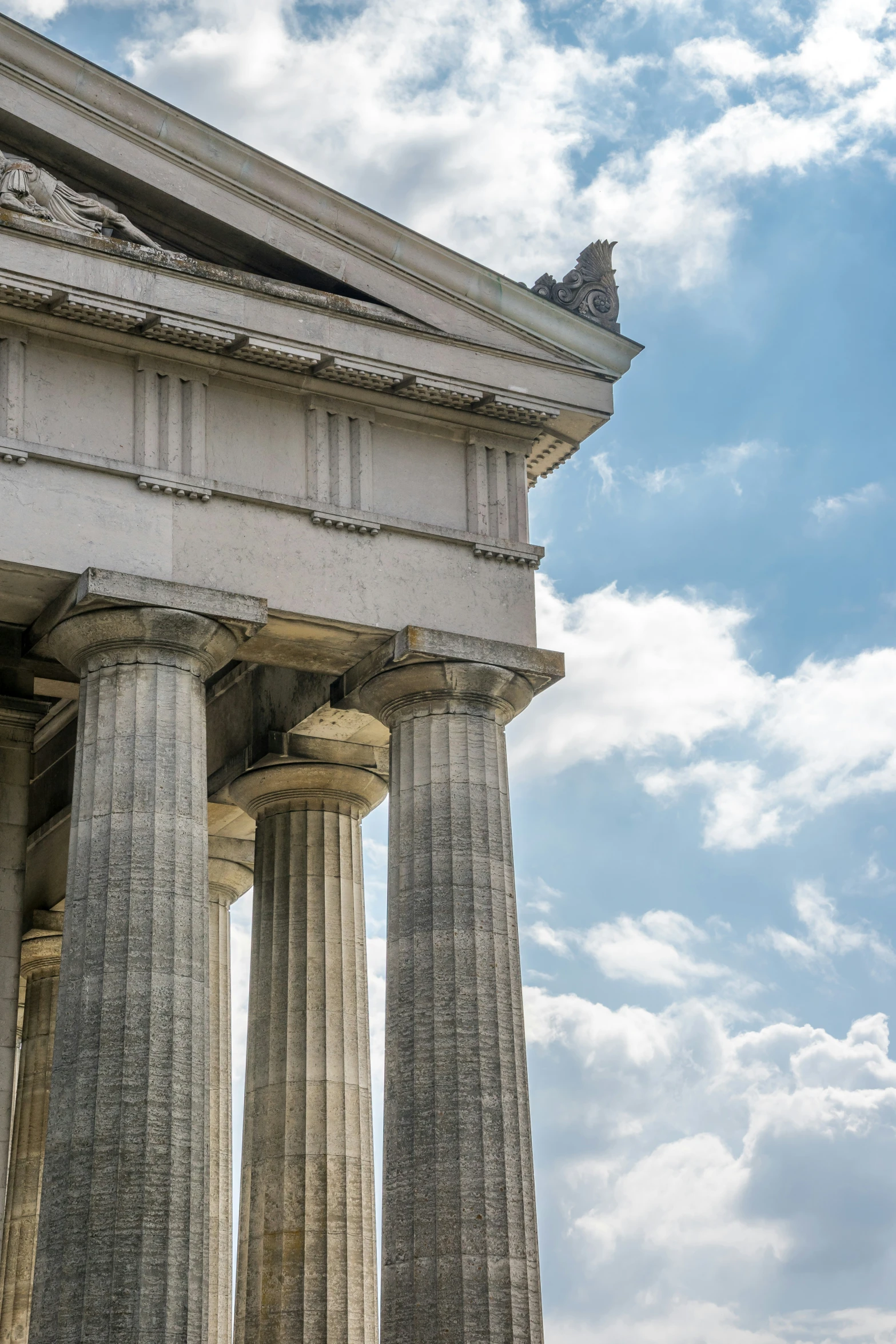 two large pillars against a blue cloudy sky