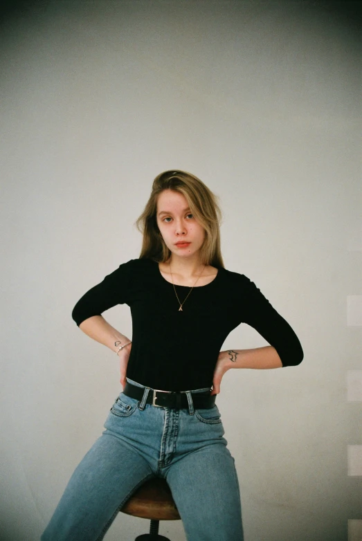 the young woman is sitting on the chair posing for a po