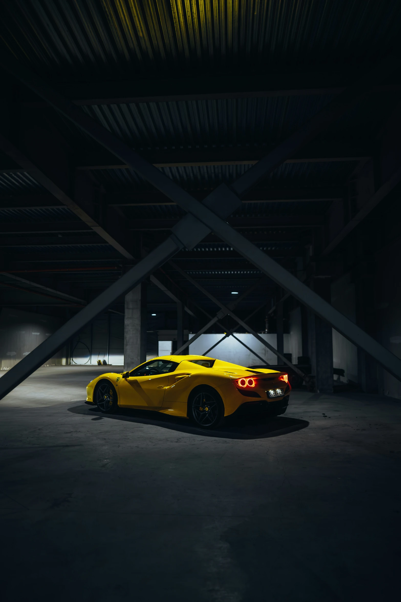 a yellow sports car sitting in the dark