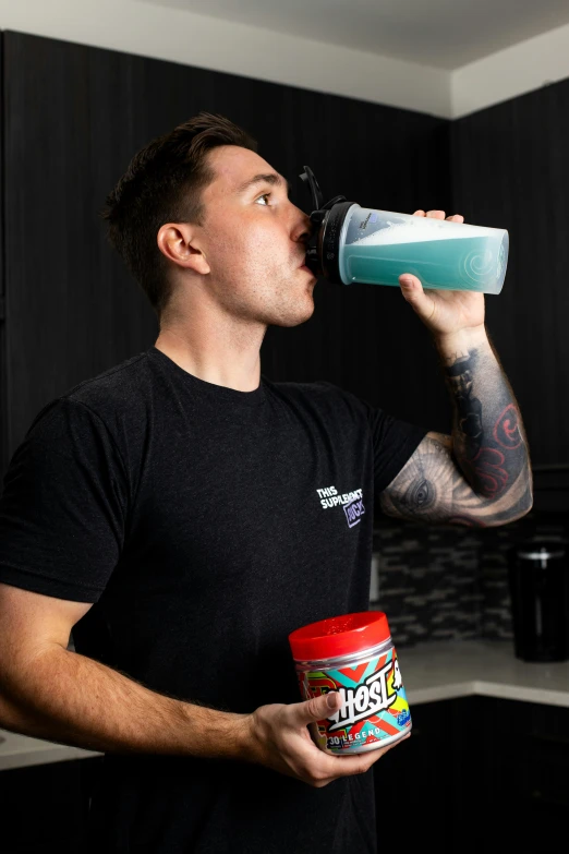 a young man sipping out a drink in the kitchen