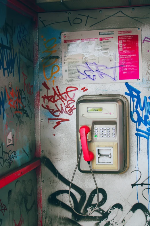 an old phone and graffiti on the wall